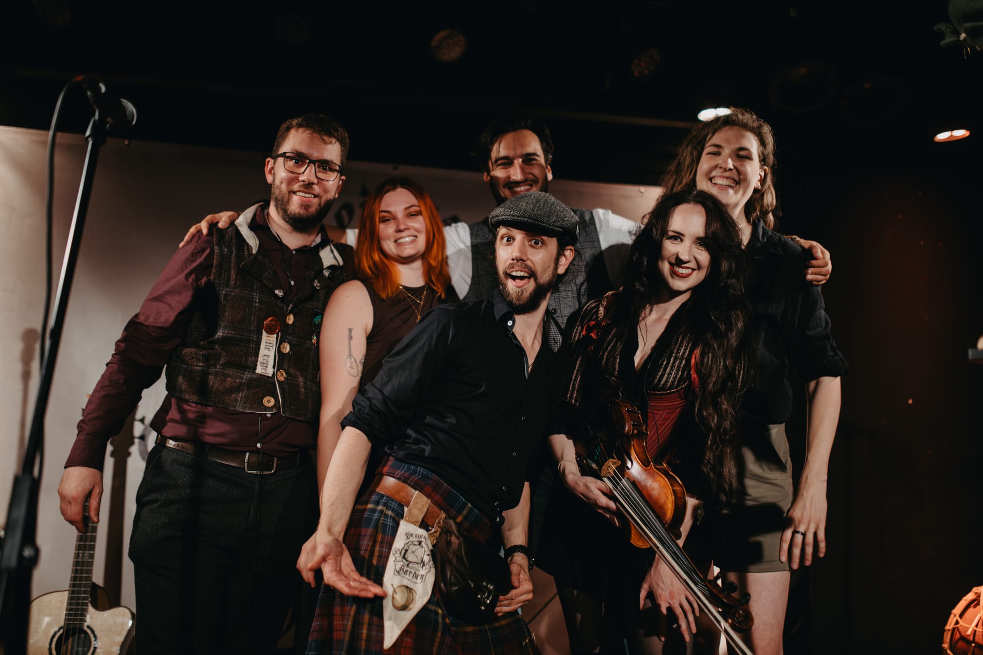 Our six musicians smiling euphorically and hugging one another.